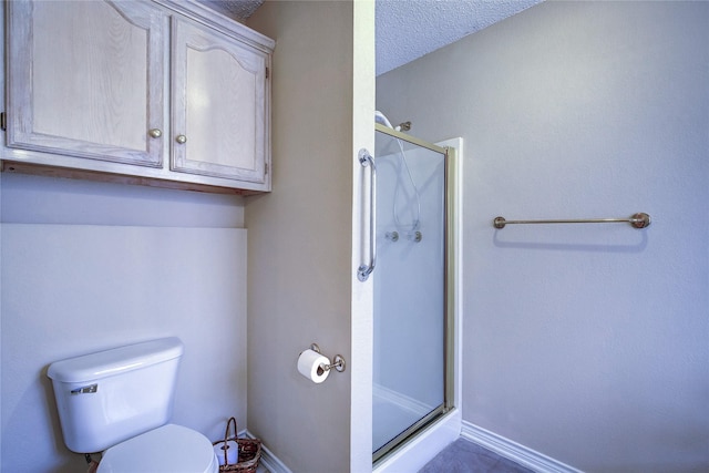 bathroom featuring a shower stall, toilet, and baseboards