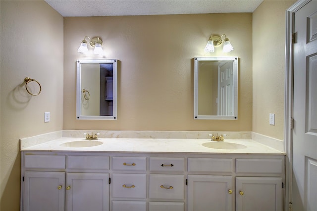 bathroom with a textured ceiling and dual bowl vanity