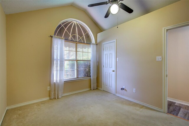 empty room featuring ceiling fan, light hardwood / wood-style flooring, and lofted ceiling