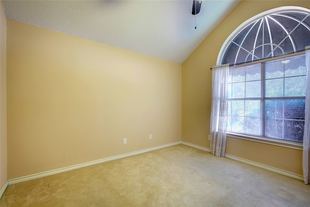 carpeted empty room with vaulted ceiling