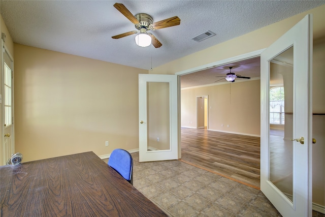 interior space featuring ceiling fan, a textured ceiling, french doors, and light hardwood / wood-style floors