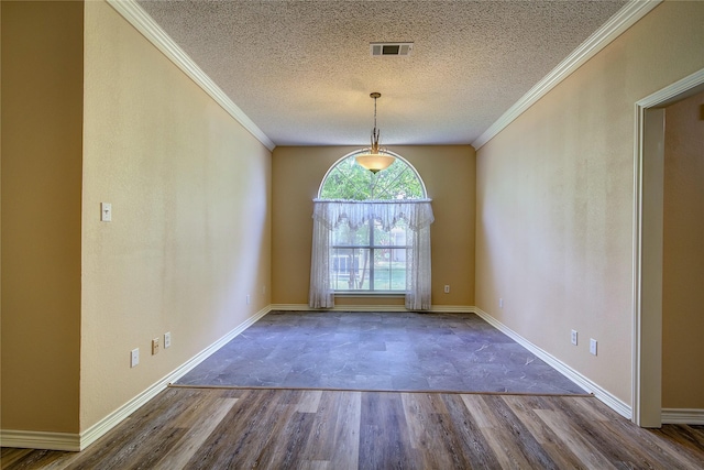 unfurnished dining area featuring ornamental molding, a textured ceiling, baseboards, and wood finished floors