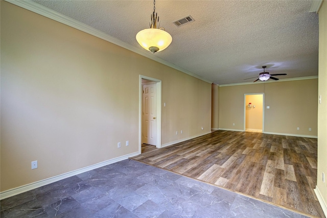 spare room featuring crown molding, visible vents, a ceiling fan, wood finished floors, and baseboards