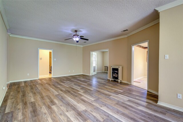 unfurnished living room with ceiling fan, hardwood / wood-style flooring, ornamental molding, and a textured ceiling