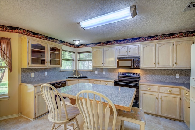 kitchen with sink, black appliances, backsplash, and light tile patterned flooring