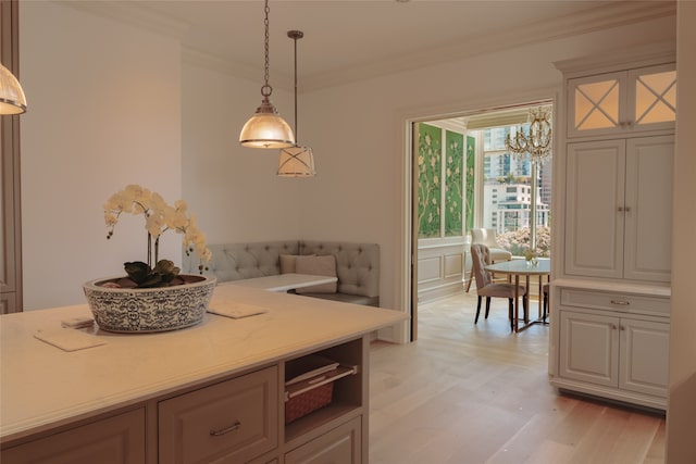 kitchen with light hardwood / wood-style floors, crown molding, hanging light fixtures, and a chandelier