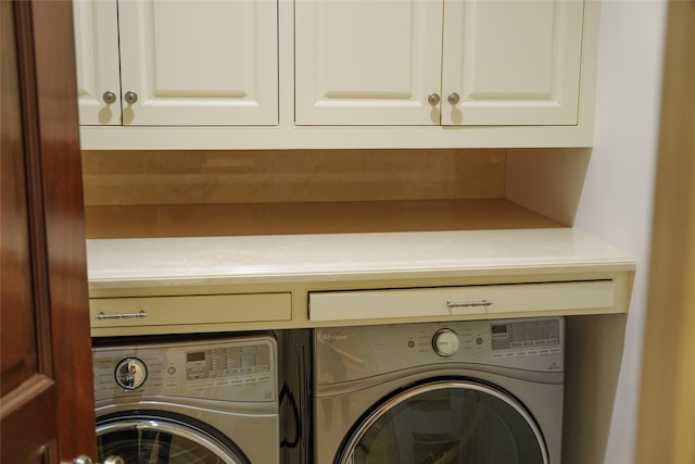 washroom with cabinet space and washing machine and clothes dryer