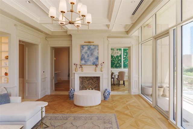 living area with ornamental molding, a healthy amount of sunlight, a decorative wall, and coffered ceiling