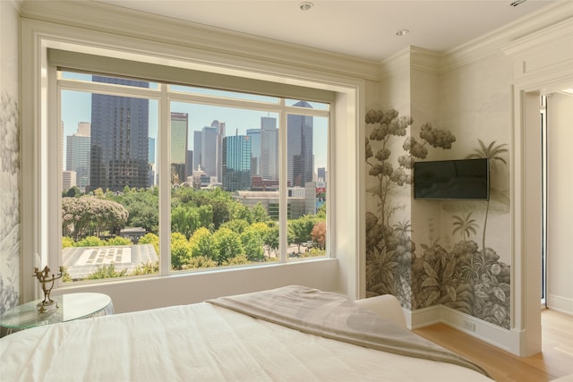 bedroom featuring crown molding and light hardwood / wood-style flooring