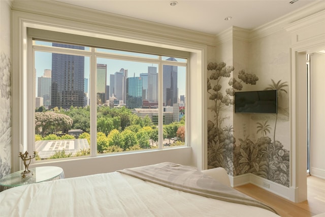 bedroom featuring crown molding, wood finished floors, and baseboards