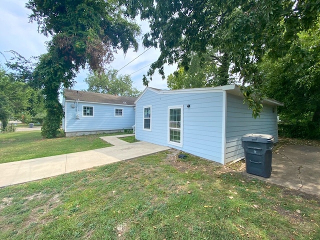 back of property with a yard and a patio