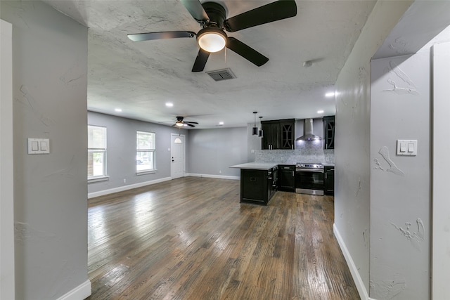 kitchen with ceiling fan, backsplash, dark wood-type flooring, wall chimney exhaust hood, and stainless steel electric range oven