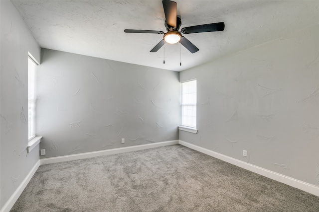 empty room featuring ceiling fan and carpet