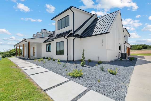 view of front facade with cooling unit and a front lawn