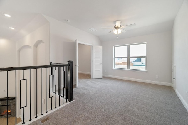 carpeted spare room featuring lofted ceiling and ceiling fan