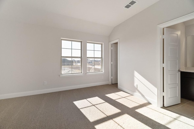 empty room with vaulted ceiling and light carpet