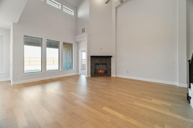 living room featuring hardwood / wood-style flooring, ceiling fan, and a high ceiling