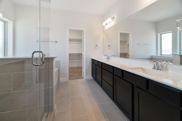 clothes washing area featuring cabinets, washing machine and dryer, and light tile patterned floors