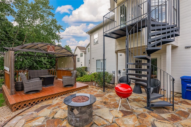 view of patio / terrace with an outdoor fire pit and a balcony