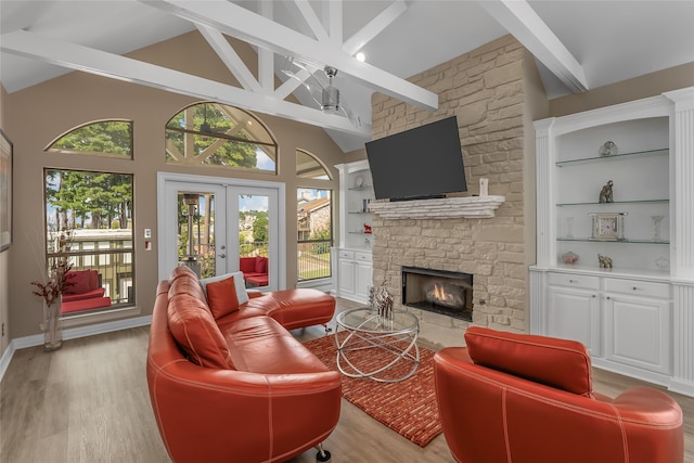 living room featuring a fireplace, french doors, light hardwood / wood-style floors, and built in shelves