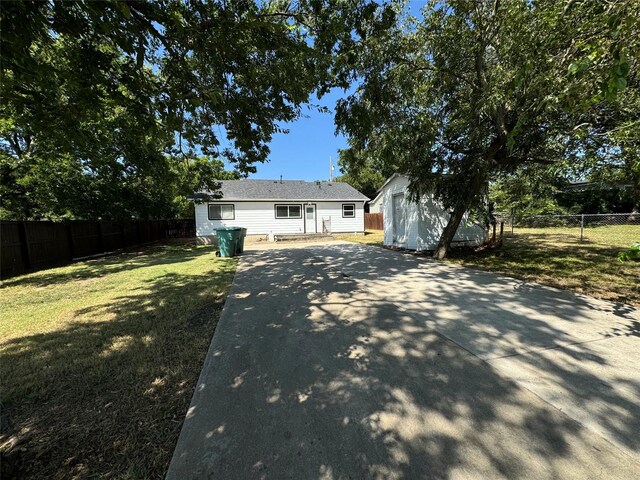 view of front of property with an outdoor structure and a front lawn