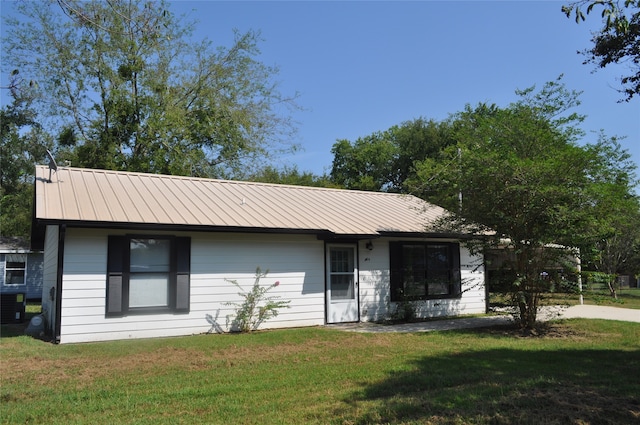 ranch-style house featuring cooling unit and a front yard