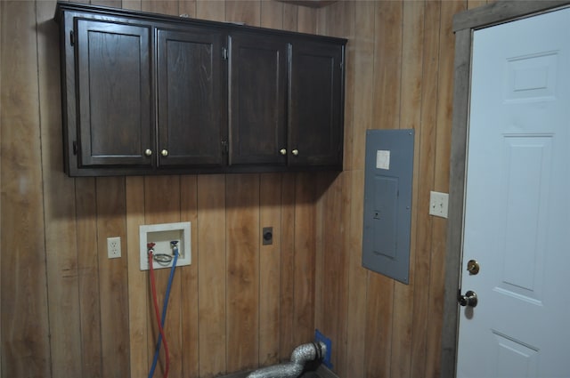 washroom featuring electric panel, washer hookup, cabinets, wooden walls, and electric dryer hookup