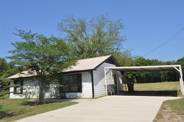 view of side of home with a carport and a yard