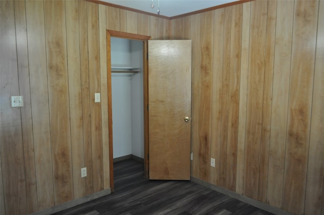 unfurnished bedroom featuring dark hardwood / wood-style floors, ornamental molding, and a closet