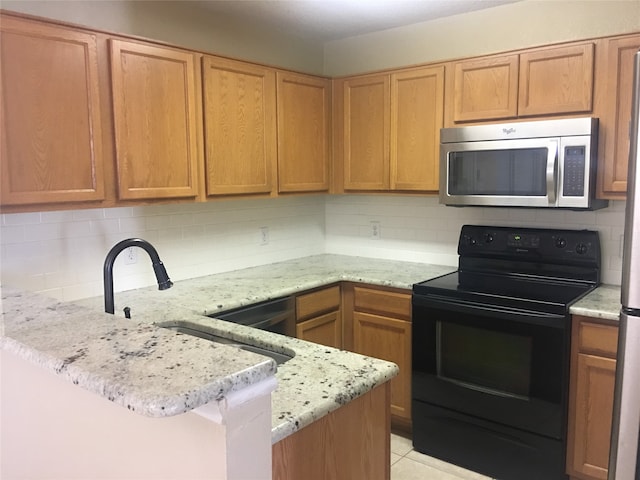 kitchen with light tile patterned flooring, tasteful backsplash, light stone counters, and black appliances