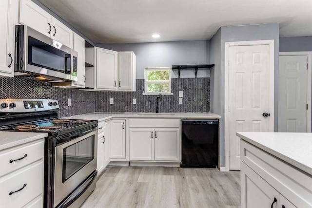 kitchen featuring appliances with stainless steel finishes, sink, light hardwood / wood-style flooring, and backsplash