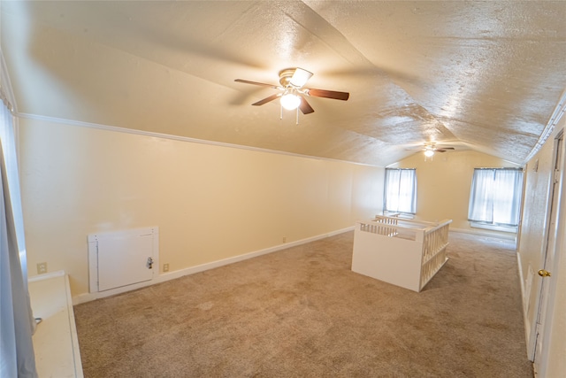 additional living space featuring ceiling fan, light colored carpet, a textured ceiling, and lofted ceiling