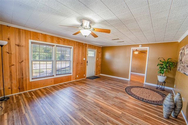 entryway with ceiling fan, wooden walls, and hardwood / wood-style floors