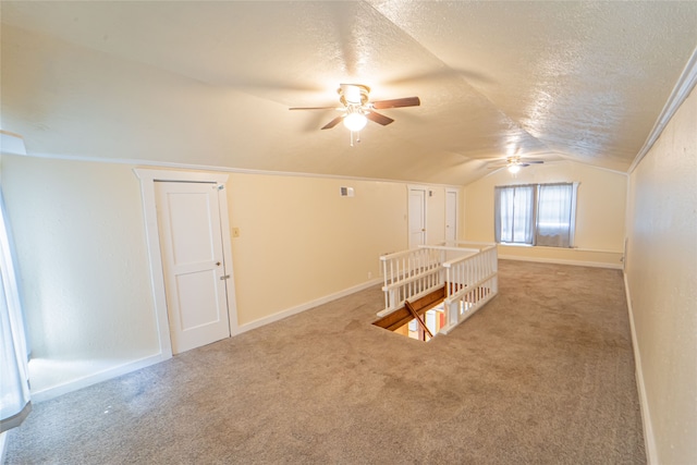 bonus room with ceiling fan, lofted ceiling, a textured ceiling, and light carpet