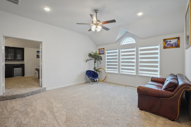 living area with ceiling fan, lofted ceiling, and light carpet