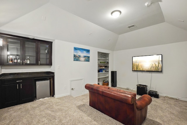 living room featuring built in features, indoor bar, vaulted ceiling, and light colored carpet