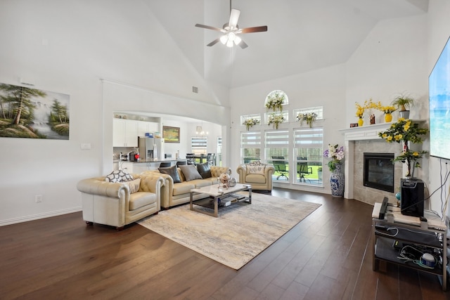 living room with ceiling fan, a fireplace, high vaulted ceiling, and wood-type flooring