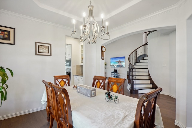 dining room with dark hardwood / wood-style flooring, a tray ceiling, and a chandelier