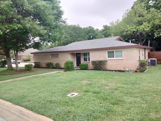 ranch-style home with cooling unit and a front lawn