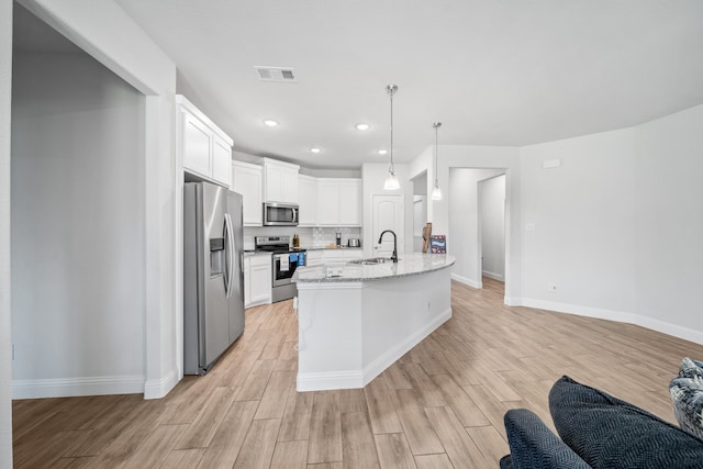 kitchen featuring white cabinetry, stainless steel dishwasher, light wood-type flooring, pendant lighting, and sink