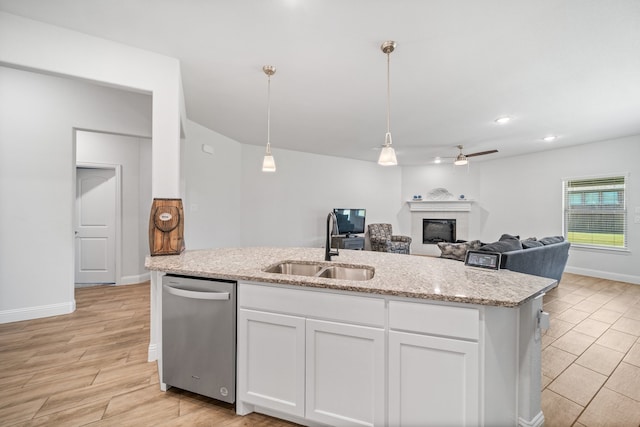 dining area with ceiling fan with notable chandelier, a tiled fireplace, and light wood-type flooring