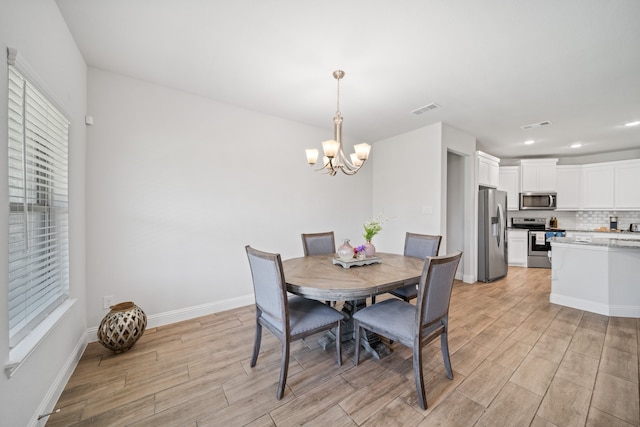 dining room with a chandelier, hardwood / wood-style flooring, and a healthy amount of sunlight