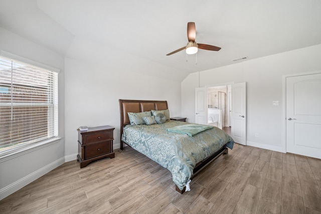 bedroom with ceiling fan, vaulted ceiling, multiple windows, and hardwood / wood-style floors