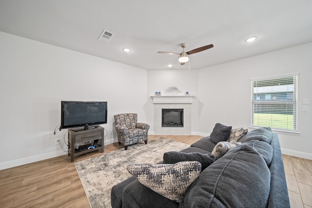 living room featuring light hardwood / wood-style floors, sink, and ceiling fan with notable chandelier