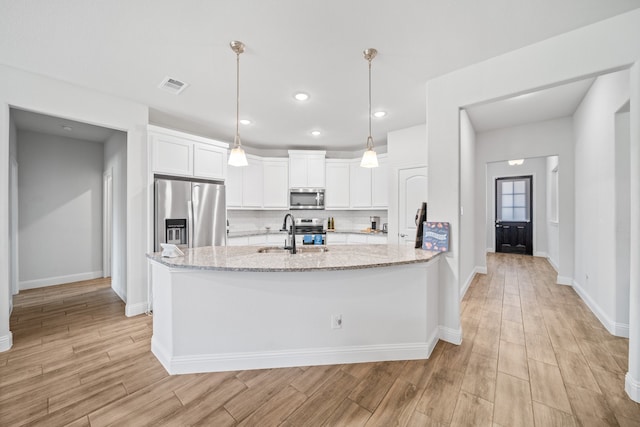 living room featuring light hardwood / wood-style floors, a tile fireplace, and ceiling fan with notable chandelier