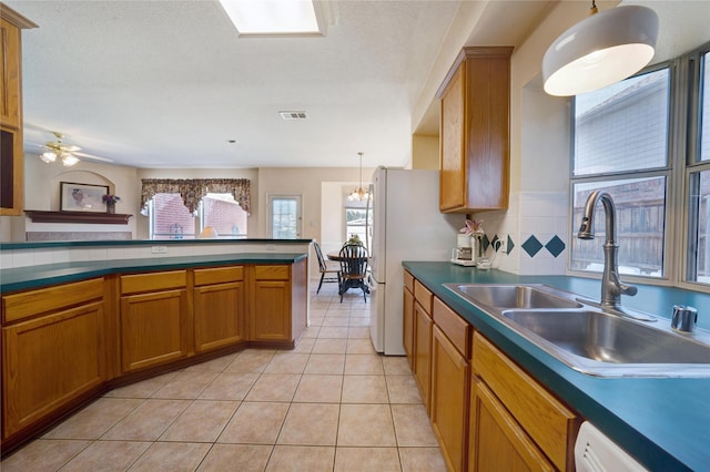 kitchen with decorative light fixtures, sink, dishwasher, light tile patterned floors, and decorative backsplash