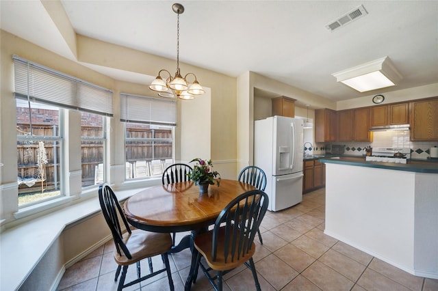 tiled dining space featuring an inviting chandelier