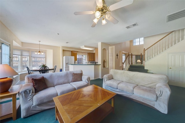 living room with ceiling fan with notable chandelier