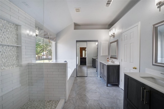 bathroom with separate shower and tub, vaulted ceiling, tile walls, and vanity