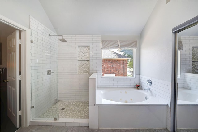 bathroom featuring lofted ceiling and plus walk in shower